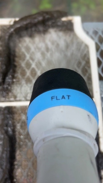 A vacuum hose held against the inside of an air conditioner