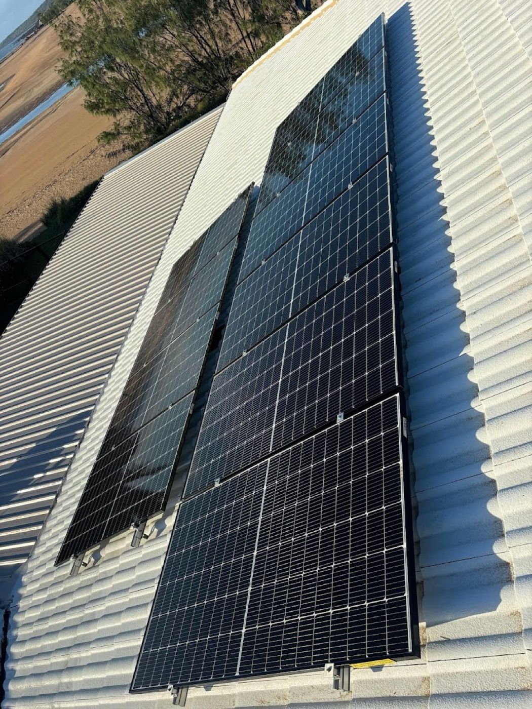 A solar array on a metal roof seen along the line of the panels